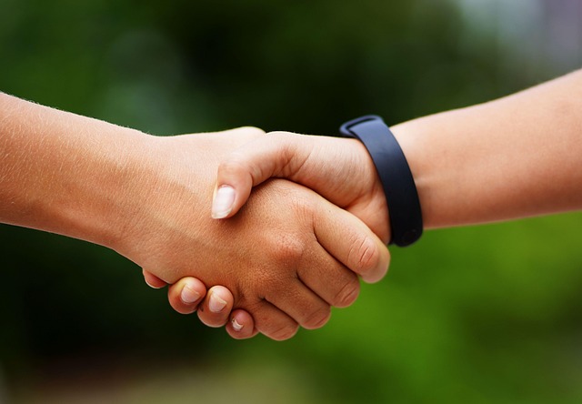 Teens shake hands before a match showing good sportsmanship taught by wrestler moms.