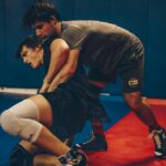 Two male wrestlers engaged in a competitive match in an indoor gym setting.