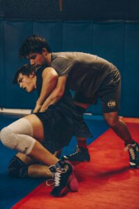 Two male wrestlers engaged in a competitive match in an indoor gym setting.